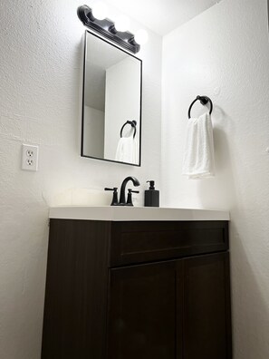 Tina, secadora de cabello, toallas, papel de baño 