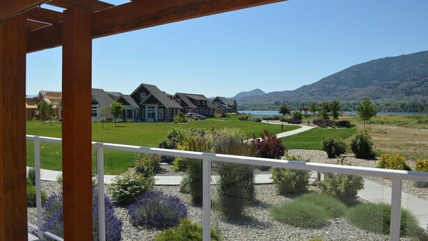 A residential area with houses, a clear sky, and a mountain in the background. - Tempranillo Suite on Osoyoos Lake #269b (Osoyoos)