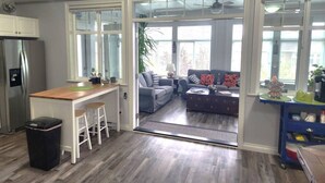 A modern kitchen with a bar area, a dining table, and a living room with a sofa and a coffee table. - Tempranillo Suite on Osoyoos Lake #269b (Osoyoos)