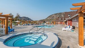 A pool area with multiple pools, sun loungers, and wooden pergolas. - Tempranillo Suite on Osoyoos Lake #269b (Osoyoos)