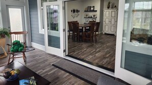 A dining area with a table and chairs, a rocking chair, and a view into a kitchen. - Tempranillo Suite on Osoyoos Lake #269b (Osoyoos)