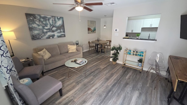 A modern living room with a sofa, coffee table, and a dining area with chairs.