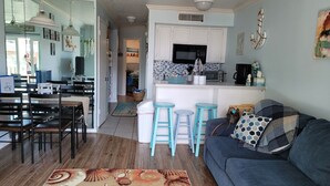 A compact living space with a dining area, kitchen, and a sofa. - Cute ocean view beach front condo w private balcony . Great LOCATION! Sleeps 6. (Galveston)
