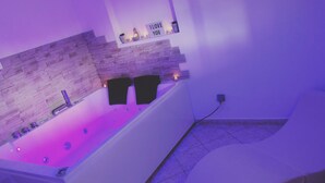 Ein modernes Badezimmer mit einer Steinsturzwand, einer Badewanne und einem Schild mit der Aufschrift 'I love you'.