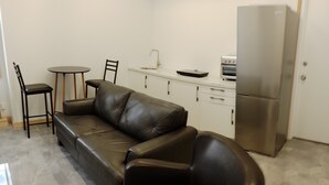 A modern kitchen with a sofa, a dining table, and chairs. - Sandwich Boutique Hotel (Windsor)