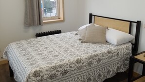 A bedroom with a bed, a window, a radiator, and a chair. - Sandwich Boutique Hotel (Windsor)