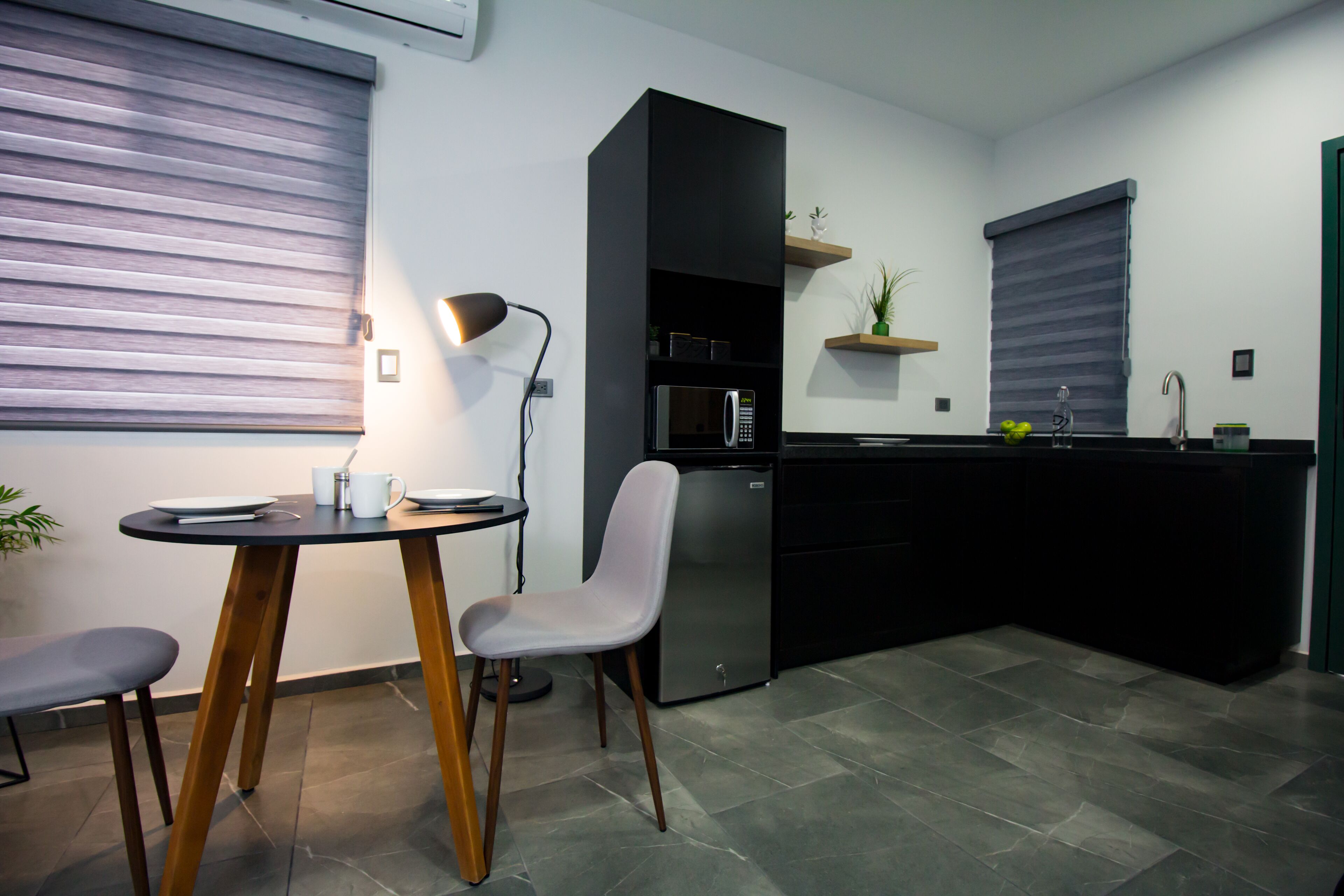 A modern kitchen with a dining area, including a table, chairs, and a refrigerator.