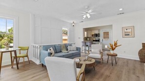 A spacious living area with a sofa, chairs, a dining table, and a kitchen in the background. - Carriage Manor- Right next to the  Fountain of Youth & Beach.
Pets are welcomed! (St. Augustine)