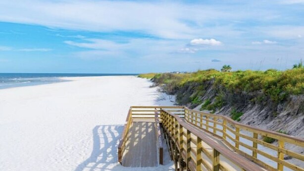 A wooden boardwalk leading to a sandy beach with a clear sky. - Carriage Manor- Right next to the  Fountain of Youth & Beach.
Pets are welcomed! (St. Augustine)