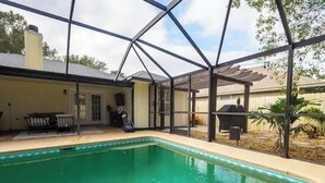 A swimming pool with a covered patio area, a barbecue grill, and a fenced yard. - Super Clean Fantastic Pool Home Near Everything (Orange Park)