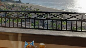 Un balcón con vista a la playa y al océano.