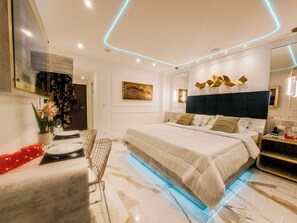 A modern bedroom with a large bed, a desk, and a chair. - GLÓRIA PLAZA HOTEL (São Paulo)