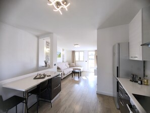 Una cocina moderna con comedor, sofá y un amplio ventanal.