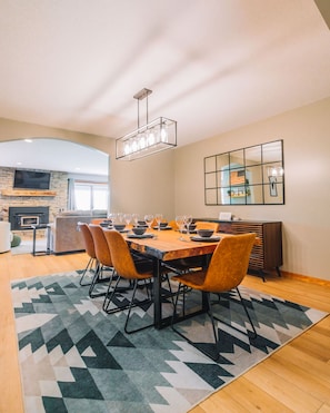 Un coin repas avec une table en bois dressée pour six personnes, entourée de six chaises.