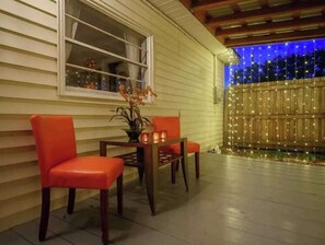 An outdoor patio with two red chairs, a small table, and a potted plant. - Picture Perfect Paradise 3br / 3ba (Orange Park)