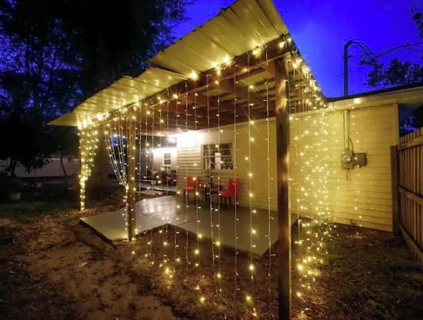 Une maison dotée d’un porche abrité, décoré de guirlandes lumineuses.