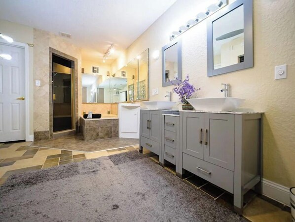 A bathroom with two sinks, a bathtub, and a large mirror. - Picture Perfect Paradise 3br / 3ba (Orange Park)