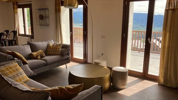 A cozy living room with a sofa, a round coffee table, and a view of a balcony with a railing. - Duplex M, huge loft in resort center (Font-Romeu-Odeillo-Via)
