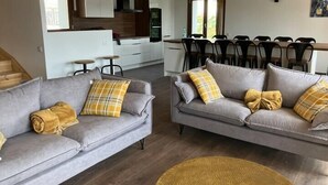 A modern living room with two grey sofas, a yellow throw, and a woven rug. - Duplex M, huge loft in resort center (Font-Romeu-Odeillo-Via)