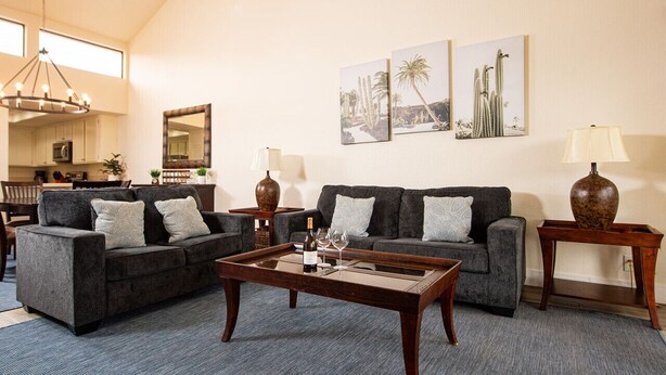 A spacious living room with two grey sofas, a wooden coffee table, and a chandelier. - Palm Desert Private Retreat  (Palm Desert)