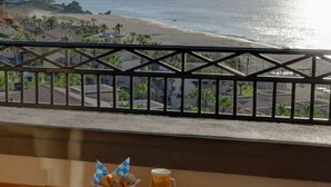 En balkong med utsikt över en strand och havet.