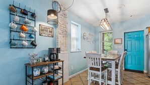 A kitchen with a coffee bar, a dining table with chairs, and a blue door. - Soulard Retreat. Fire Pit. Game Room. 3 Kings (St. Louis)