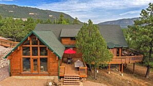 A log cabin with a deck, large windows, and a covered patio area. - Trailheads Steps Away + Stunning Views! (Pine)