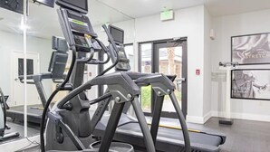 A gym with treadmills, exercise equipment, and motivational posters on the walls.