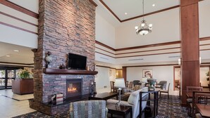 A spacious lobby with a stone fireplace, comfortable seating, and a patterned carpet. - 2 Bedrooms | Free Daily Breakfast, Outdoor Pool (El Paso)