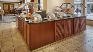 Ein Bereich mit Buffet, ausgestattet mit einer Holztresen, Glasdeckeln und einer Auswahl an Speisen.
