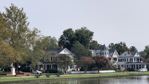A lakeside residential area with houses, a flag, and a calm water body. -  Cape Cod cottage close to Prembroke Creek (Edenton)
