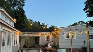 A covered patio area with outdoor furniture, string lights, and a view of the house. -  Cape Cod cottage close to Prembroke Creek (Edenton)