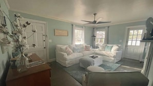 A living room with a sectional sofa, a coffee table, and a decorative vase. -  Cape Cod cottage close to Prembroke Creek (Edenton)