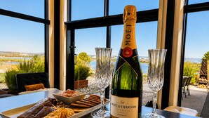 A bottle of Moët & Chandon champagne on a table with two glasses and a plate of snacks. - Coastal Calm | Luxe Stay with Views, Bath & Fire. (Mapua)
