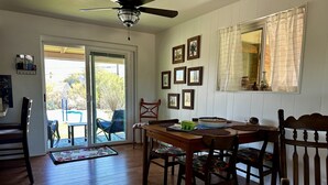 A dining area with a wooden table, chairs, and a ceiling fan. - Quiet Eco-Friendly Home Close to Downtown & Desert—Wildlife in Abundance! (Tucson)
