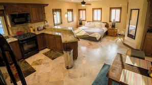 A spacious kitchen with granite countertops, a stove, and a microwave. There is a dining area with a table and chairs. - Secluded Cabo Hideaway! Walk to the beach, ample space,  pool and rooftop deck! (Cabo San Lucas)