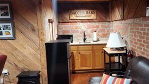 A rustic kitchen with wooden cabinets, a microwave, and a coffee machine.