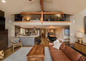 A spacious living area with a high ceiling, a dining area, and a kitchen. - 5 BR w/ Hot Tub. Mtn Views. 1 Acre. Walk to Dtwn + Ski Shuttle. (Breckenridge)
