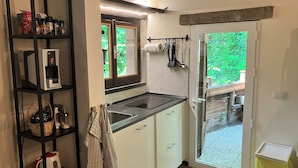 A compact kitchen with a built-in coffee maker, a sink, and a window with a view of greenery. - 1 Bed Studio - Pets - Terrace - Parking (Borgo Val di Taro)