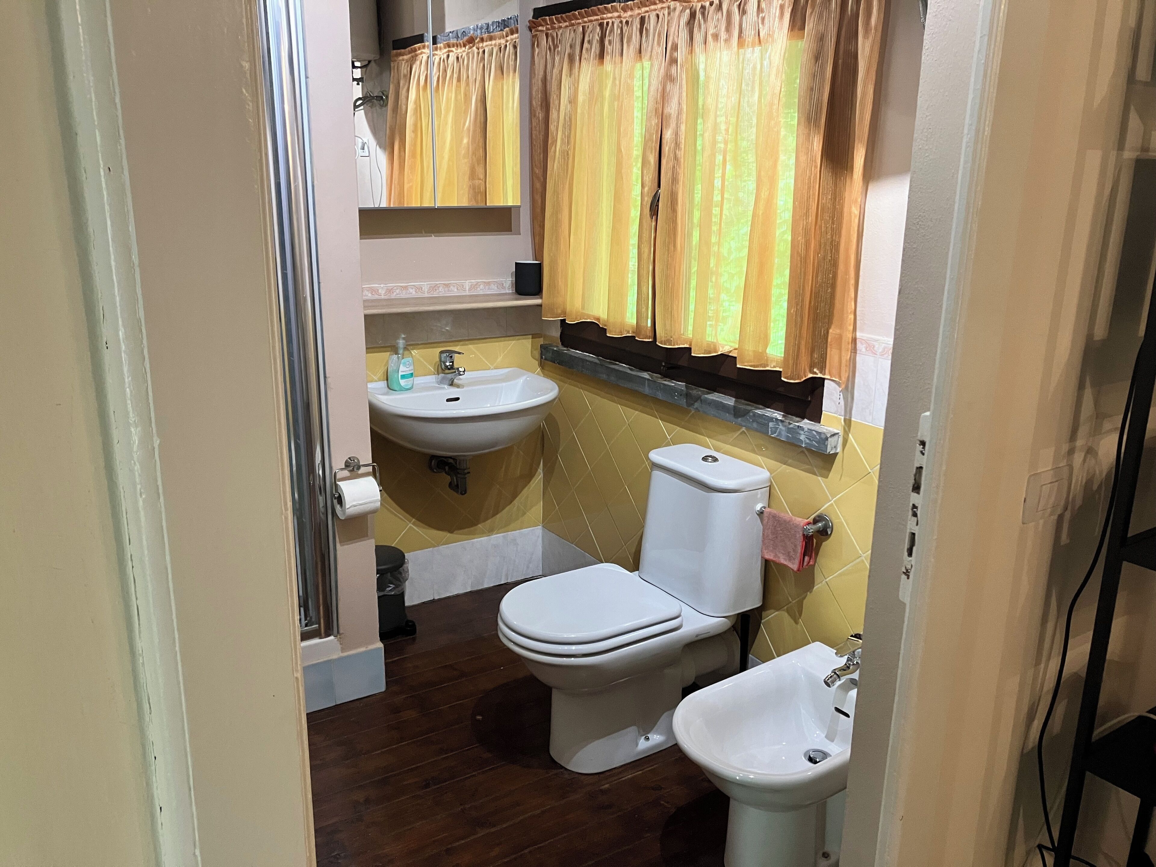 A bathroom with a toilet, bidet, and sink.