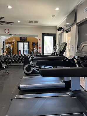 A gym with treadmills, dumbbells, and a wall-mounted TV. - 1 Bedroom Condo- Scottsdale Quarter/ Kierland (Scottsdale)