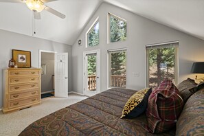 A bedroom with a large bed, a dresser, and multiple windows offering views of the outdoors. - Pet Friendly, Solitude, 15 Mins to Vallecito! (Bayfield)