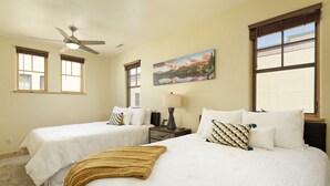 A hotel room with two single beds, a ceiling fan, a painting, and a window with blinds. - Excellent Location- Downtown Carbondale on Main St.! (Carbondale)
