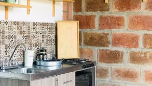 A compact kitchen with a gas stove, a microwave, and a sink. There are wooden cabinets and a patterned backsplash. - Junior Suite Mesh View with view of the mountains (Rionegro)