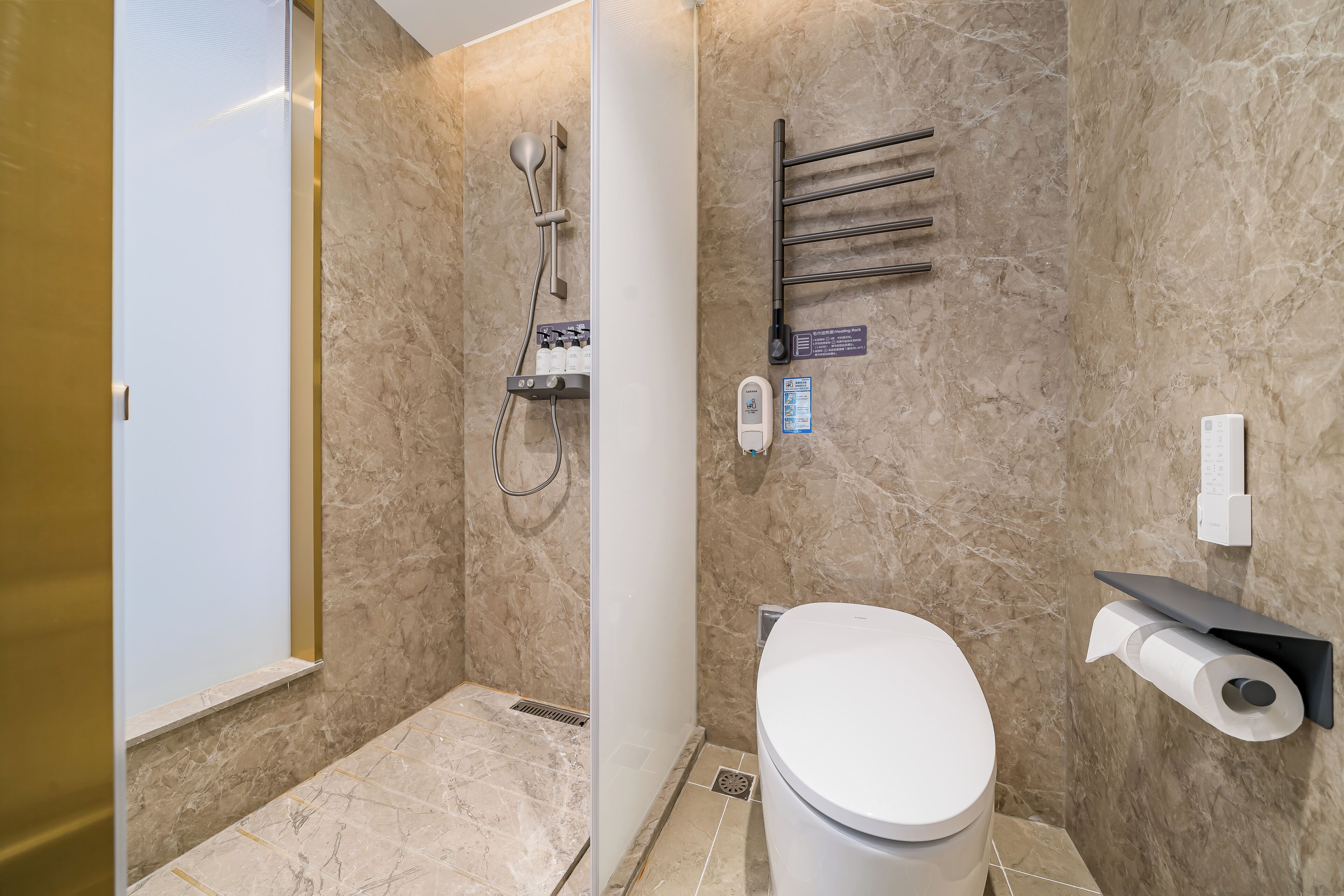A bathroom with a shower, toilet, towel rack, and a toilet paper holder.
