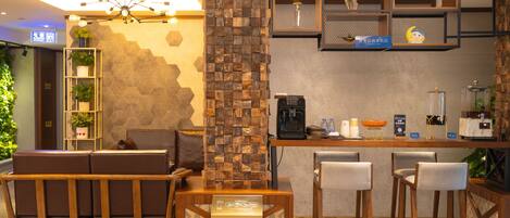 A modern bar area with wooden furniture, a coffee machine, and a fire extinguisher sign.