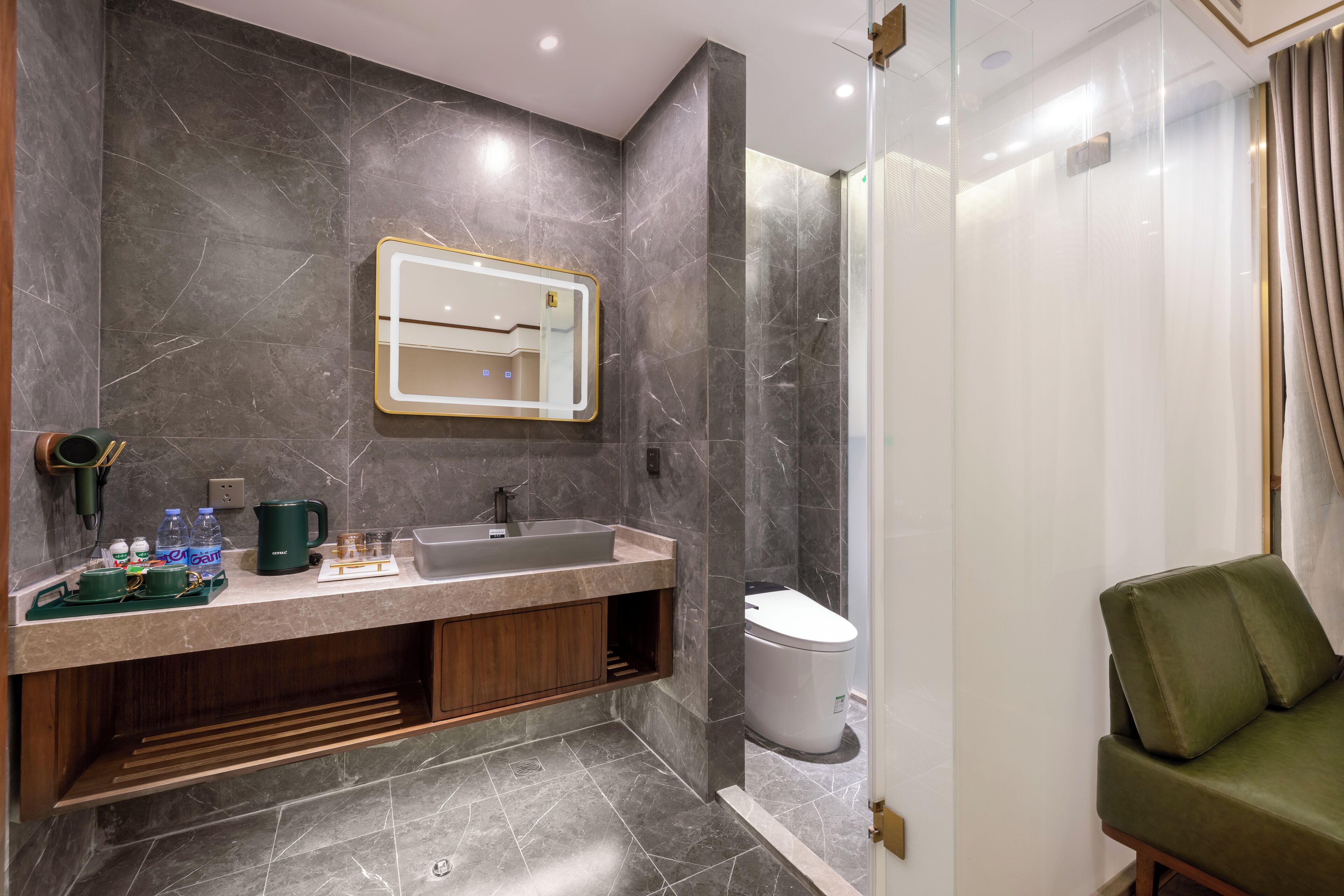 Ein modernes Badezimmer mit Marmorwand, Waschbecken inklusive Spiegel und Toilette.