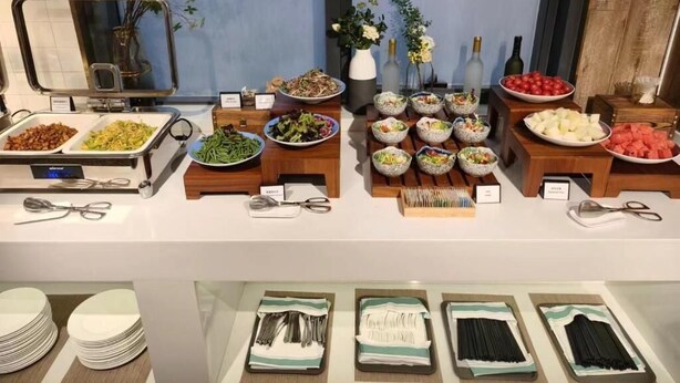 Een buffetopstelling met diverse gerechten en bestek.