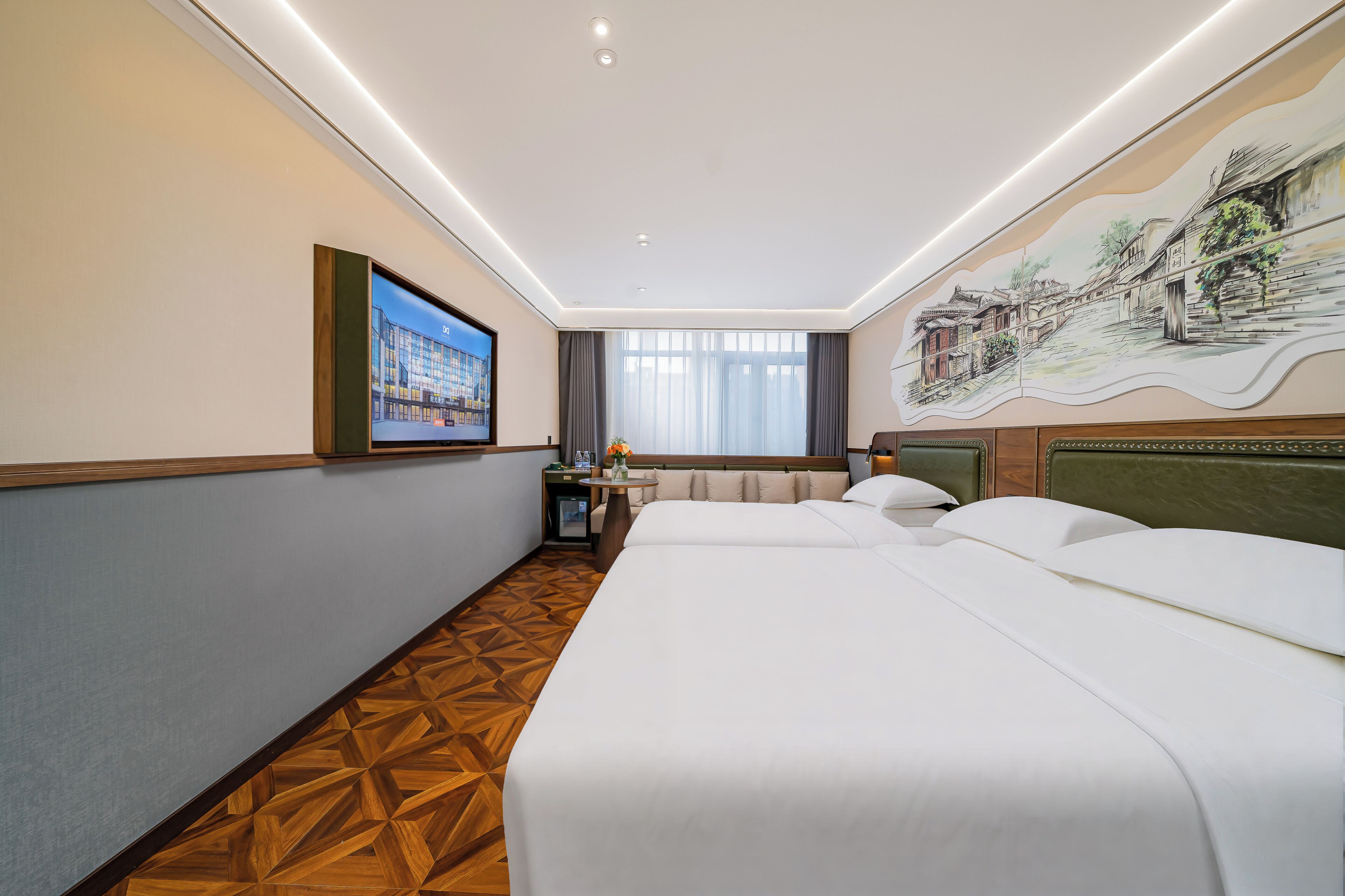Una habitación de hotel con una cama grande, una mesita con un florero, un televisor y un mural en la pared.