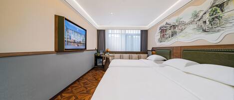 Una habitación de hotel con una cama grande, una mesita con un florero, un televisor y un mural en la pared.